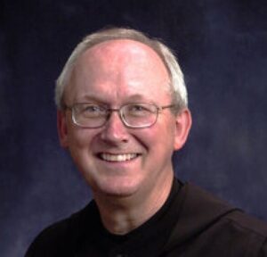 balding man with glasses.